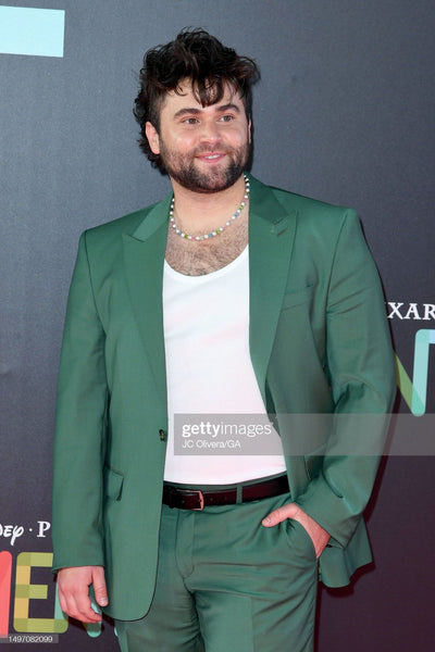Jake Borelli wearing a verdant green Ron Tomson Merino Wool suit on the red carpet at the Pixar Elemental premiere