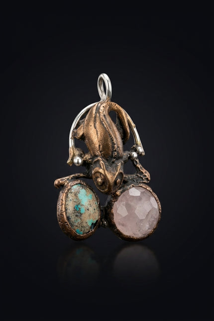 Brooch - Bronze_Silver_Turquoise_Pink stylized reptile holding two oval stones - angle