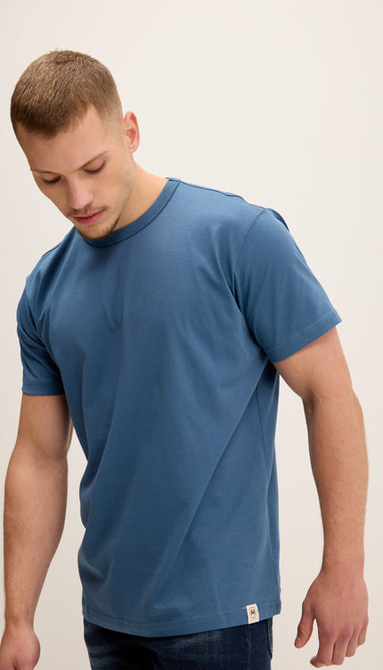 Man wearing a blue t-shirt against a plain background