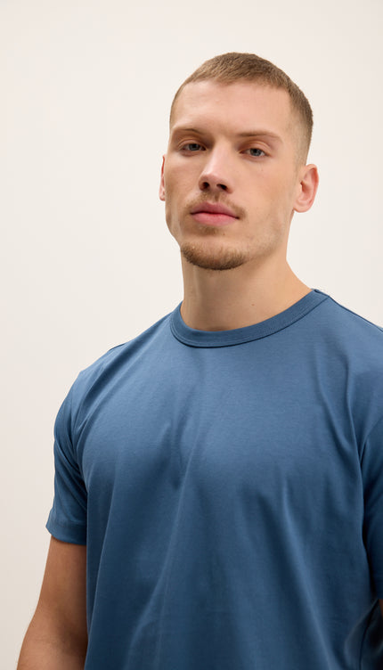 Man wearing a blue t-shirt against a plain background