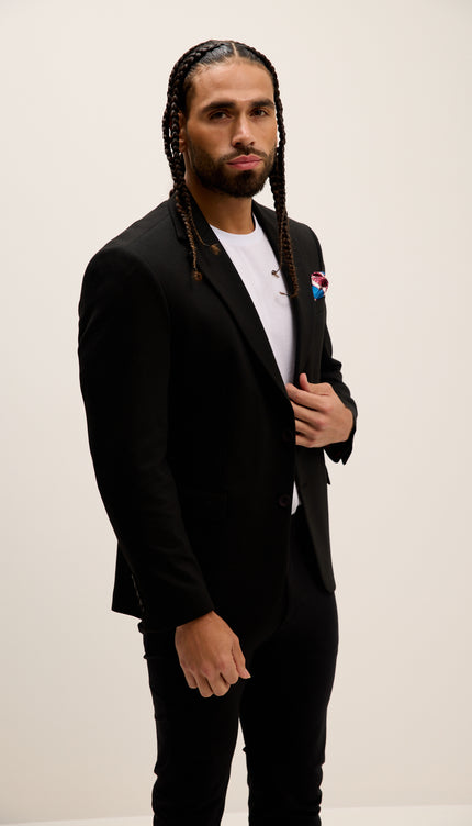 Man wearing a black suit with a white shirt and red Pepsi logo on a beige background