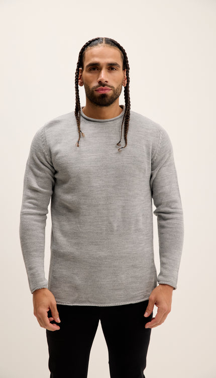 Man wearing a gray sweater against a plain background