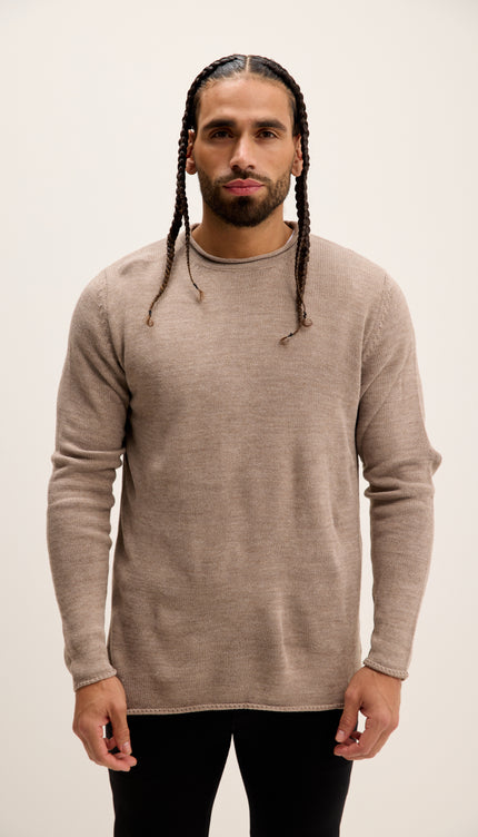Man wearing a beige sweater against a plain background