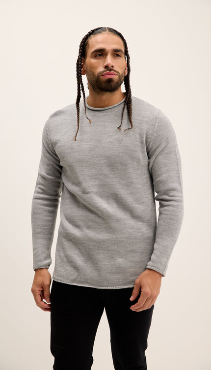 Man wearing a gray sweater against a plain background