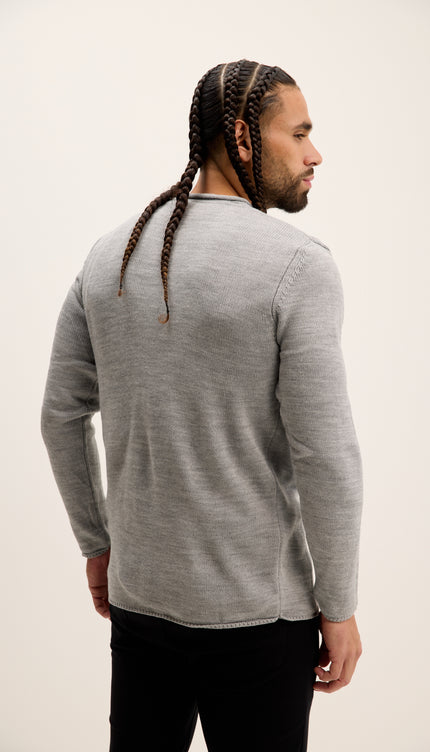 Man wearing a gray long-sleeve shirt against a plain background