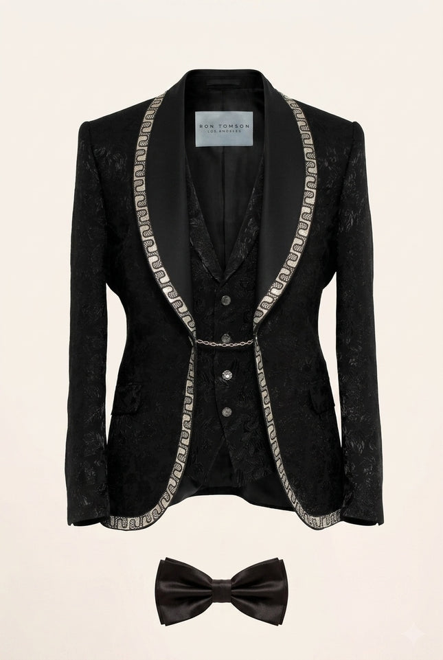 Full view of Ron Tomson Black Baroque Jacquard Mens Tuxedo Suit with silver chain trim lapels, vest, shirt, and bow-tie.