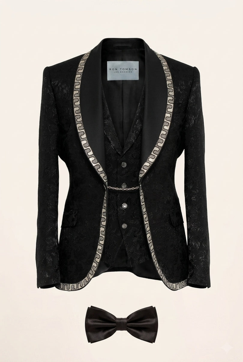 Full view of Ron Tomson Black Baroque Jacquard Mens Tuxedo Suit with silver chain trim lapels, vest, shirt, and bow-tie.