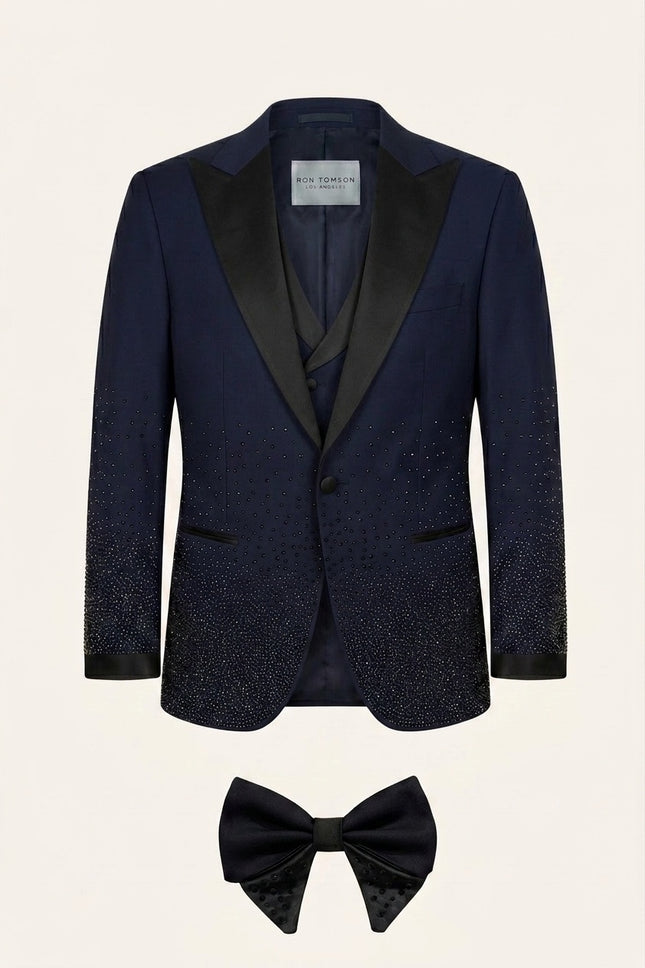 Ron Tomson Midnight Sparkle navy blue tuxedo suit with gradient rhinestone embellished jacket, satin lapels, double-breasted vest, and bow tie.